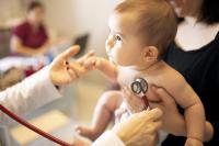 Doctor examining a baby with stethoscope